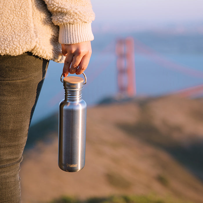 27oz-reflect-with-bamboo-cap-x1 K27SSLRF-BS-BAMBOO_reflect_bottle_bridge_lifestyle.jpg